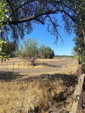 a view of a yard with wooden fence