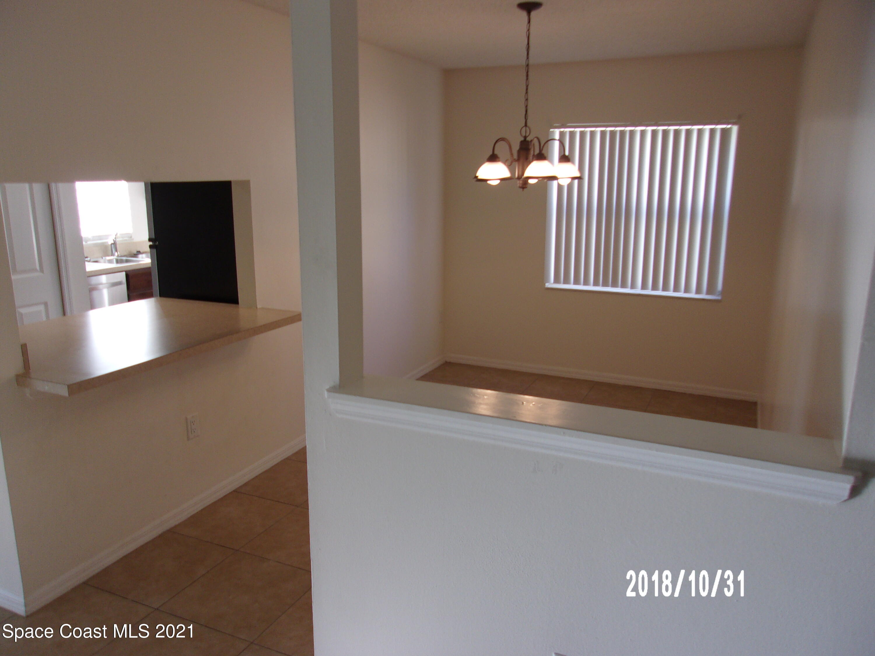 210 Spring Drive, Unit 6 Merritt Island, FL 32953 - Photo 13 of 35 a view of an empty room with window and wooden floor
