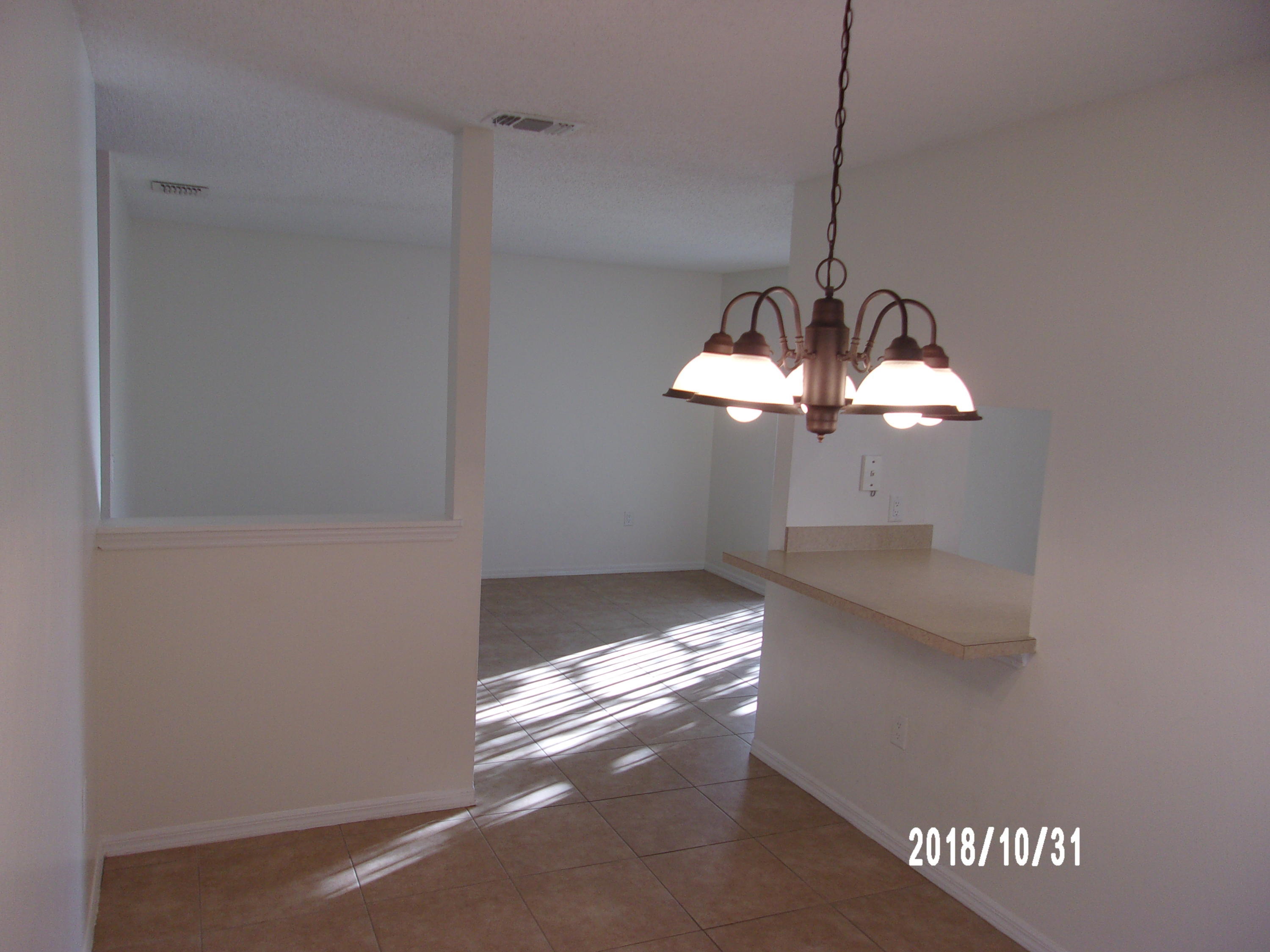 210 Spring Drive, Unit 6 Merritt Island, FL 32953 - Photo 14 of 35 a view of a chandelier fan and a wooden floor