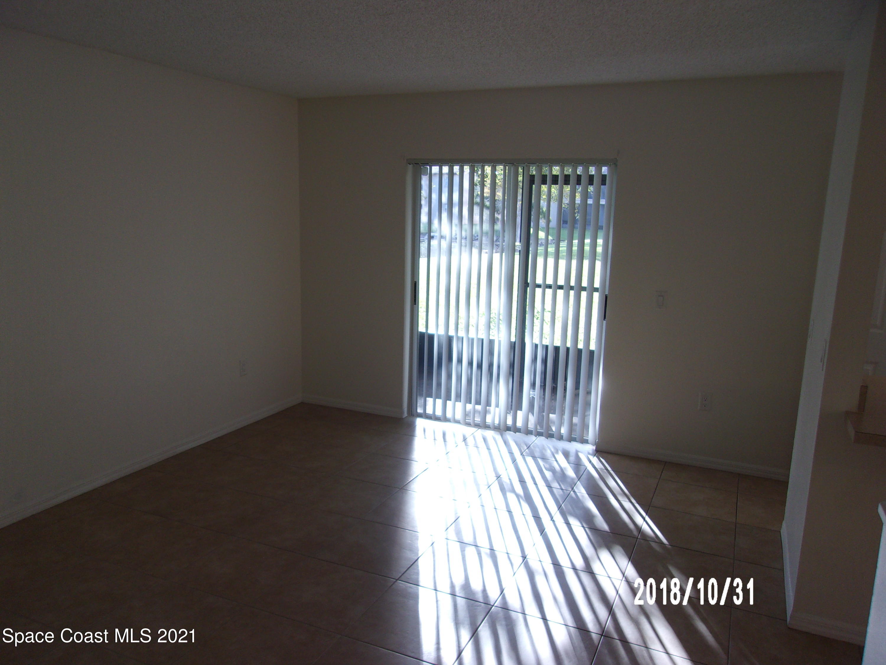 210 Spring Drive, Unit 6 Merritt Island, FL 32953 - Photo 16 of 35 an empty room with wooden floor and windows