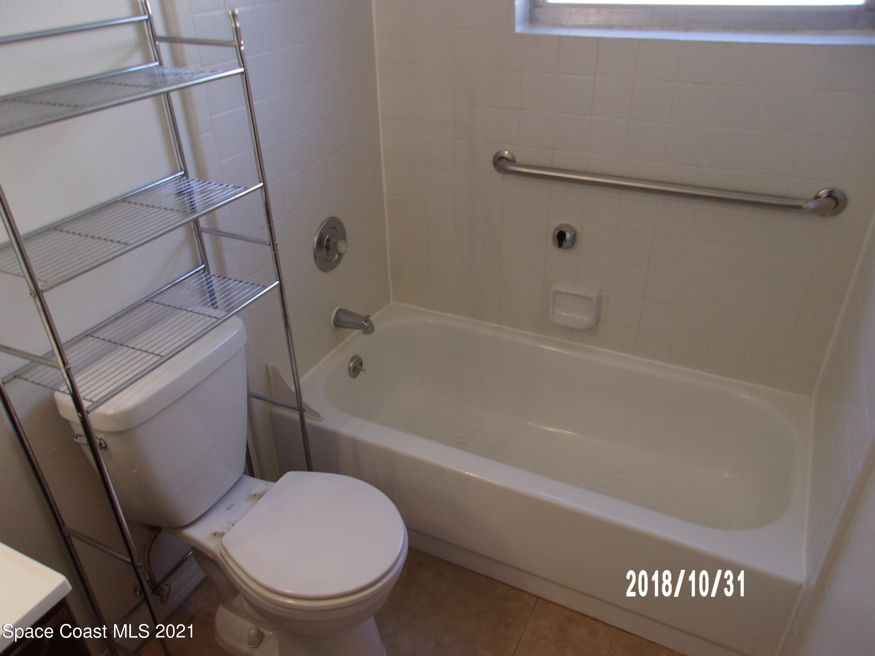 210 Spring Drive, Unit 6 Merritt Island, FL 32953 - Photo 27 of 35 a white toilet sitting next to a bath tub