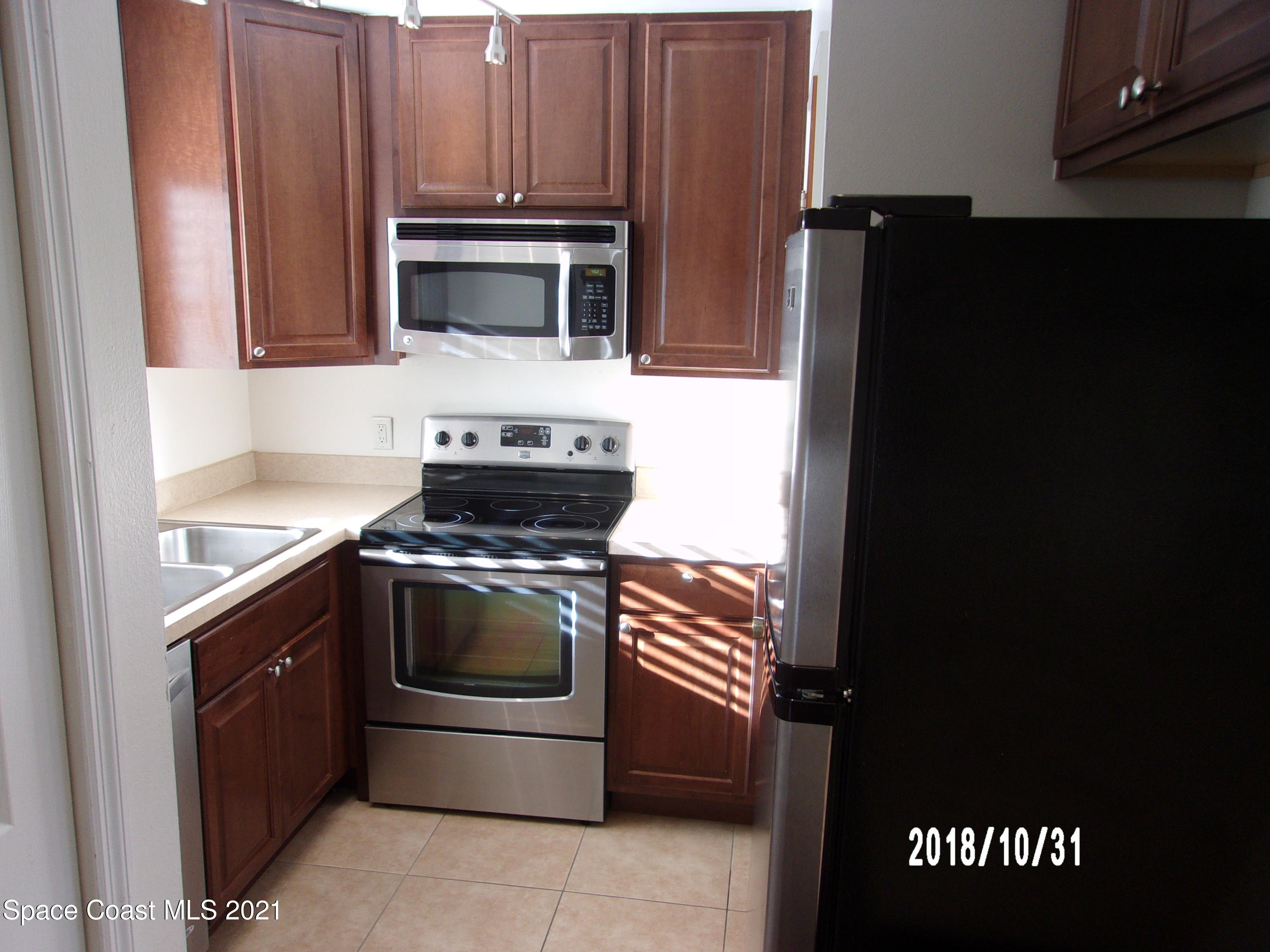 210 Spring Drive, Unit 6 Merritt Island, FL 32953 - Photo 4 of 35 a kitchen with stainless steel appliances a stove a microwave and a sink