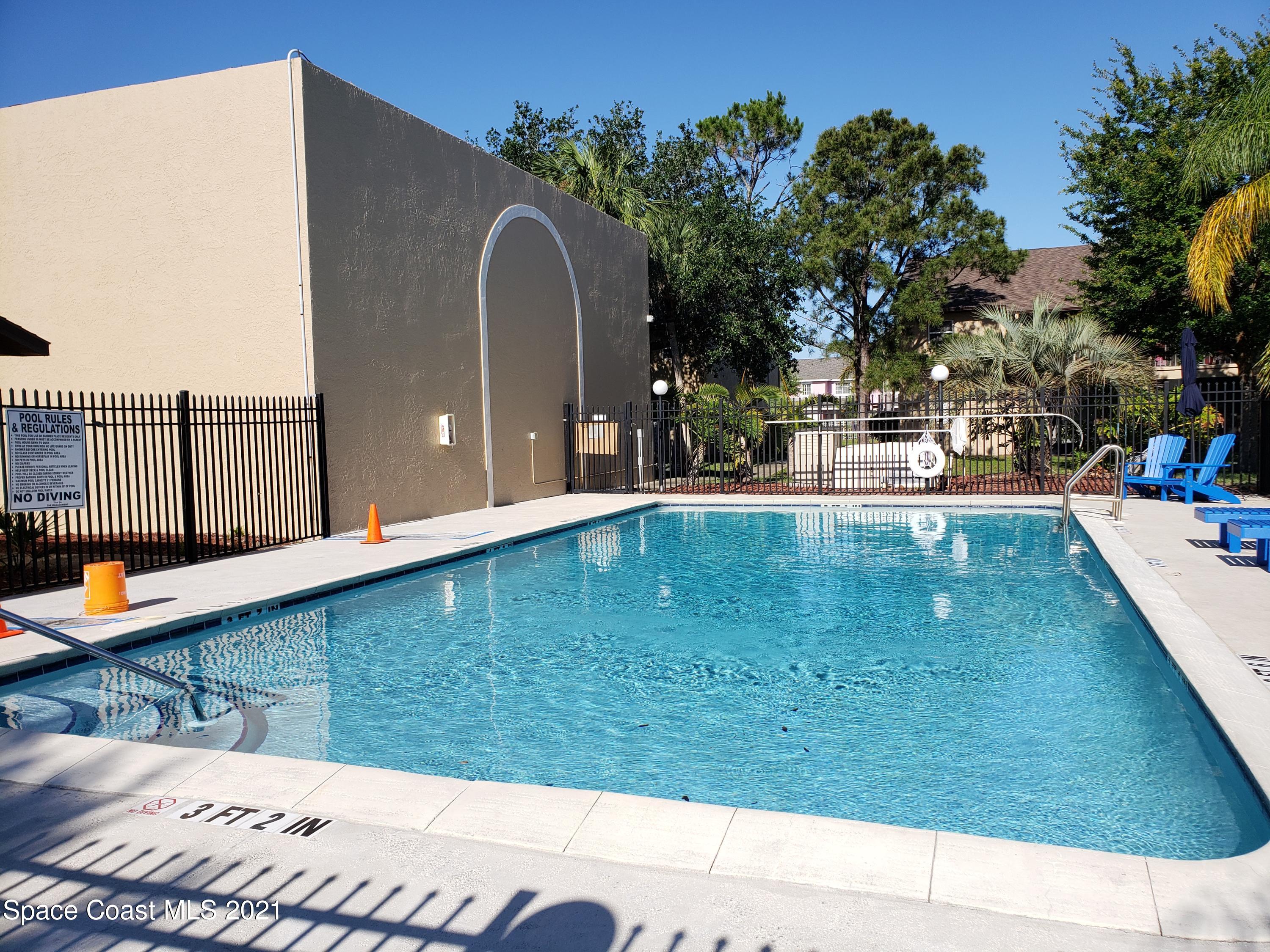 210 Spring Drive, Unit 6 Merritt Island, FL 32953 - Photo 33 of 35 a view of a swimming pool with a lounge chairs