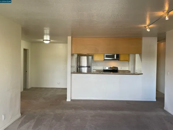 a living room with stainless steel appliances with white cabinets