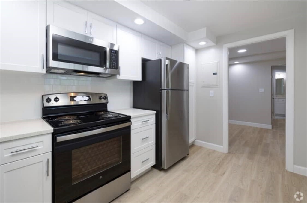 a kitchen with stainless steel appliances a stove microwave and refrigerator