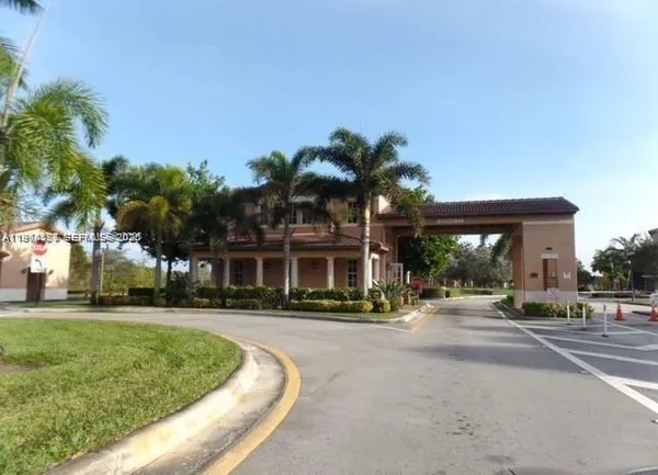 a front view of a house with a yard and palm trees