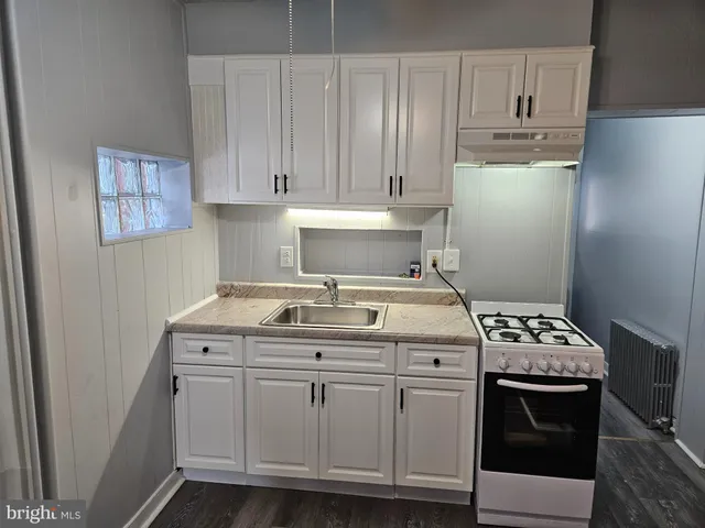 a kitchen with cabinets and white stove