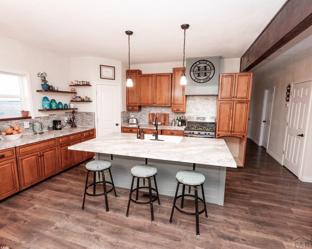 1611 Big Vista Road Rye, CO 81069 - Photo 6 of 27 a kitchen with stainless steel appliances granite countertop wooden floors and wooden cabinets