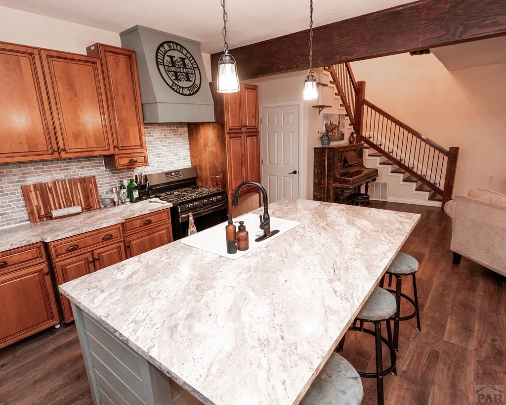 1611 Big Vista Road Rye, CO 81069 - Photo 7 of 27 a kitchen with stainless steel appliances kitchen island a table chairs in it and wooden floors