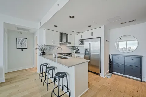 a kitchen with white cabinets and stainless steel appliances