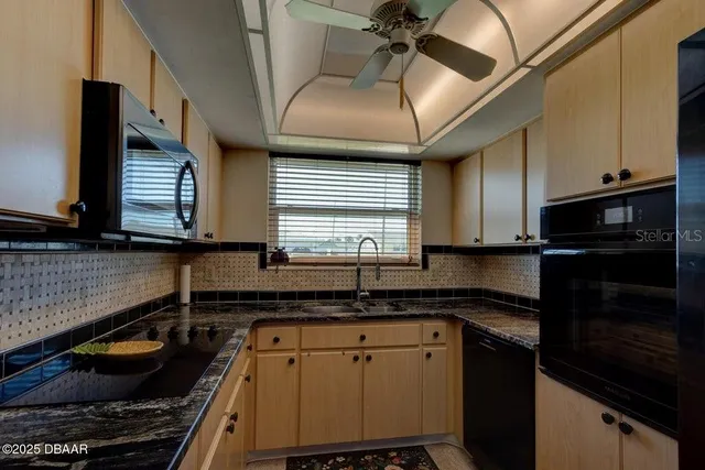 a kitchen with granite countertop a sink stainless steel appliances and cabinets