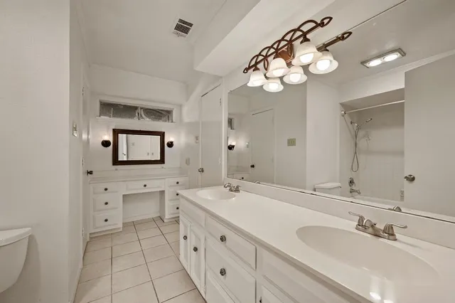 a spacious bathroom with a double vanity sink and a mirror