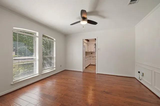 a view of an empty room with a window and wooden floor