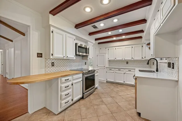 a kitchen with white cabinets appliances and sink