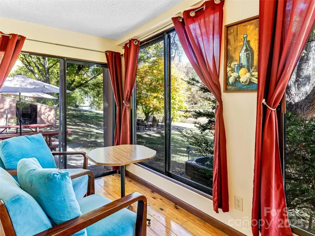 a living room with furniture a chandelier a rug and a large window