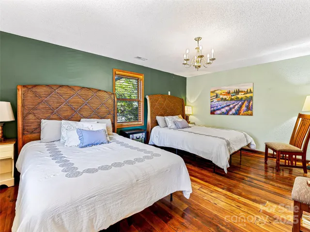 a bedroom with a bed and a chandelier