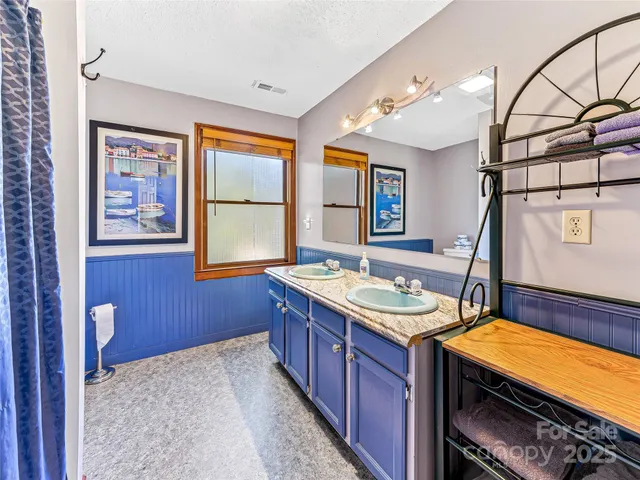 a bedroom with a bed chandelier and a window