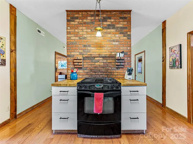 a large kitchen with stainless steel appliances granite countertop a stove and cabinets