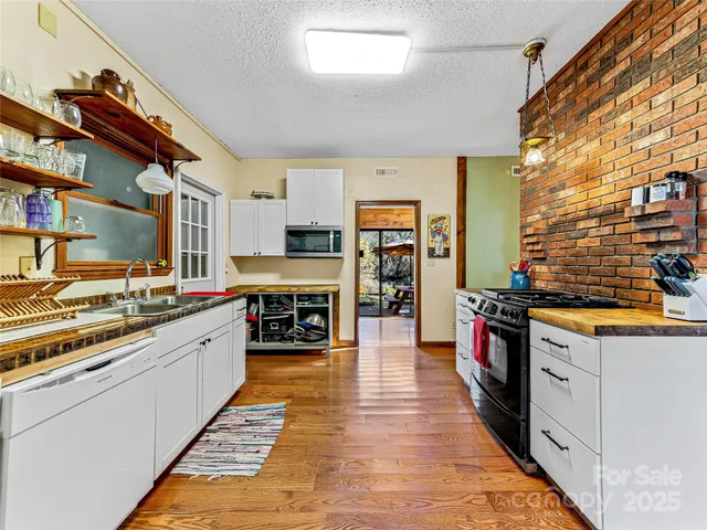 a kitchen with stainless steel appliances granite countertop a stove and cabinets