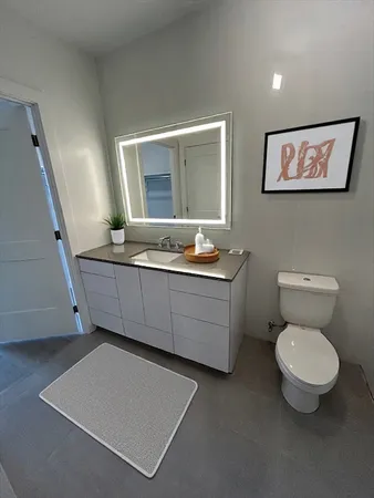 a bathroom with a toilet sink and mirror