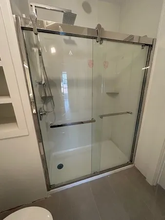 a bathroom with a glass door shower and toilet