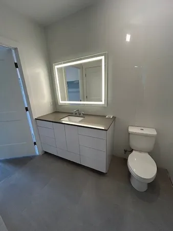a bathroom with a toilet sink and mirror
