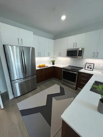 a kitchen with stainless steel appliances a stove a sink a microwave and a refrigerator