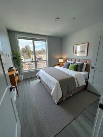 a bedroom with a bed and a large window