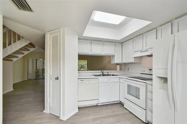 a kitchen with white cabinets and white appliances