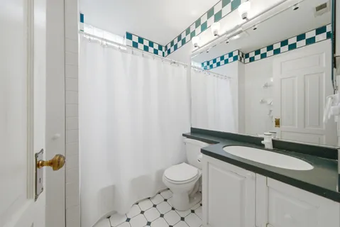 a bathroom with a granite countertop sink a mirror and a shower curtain