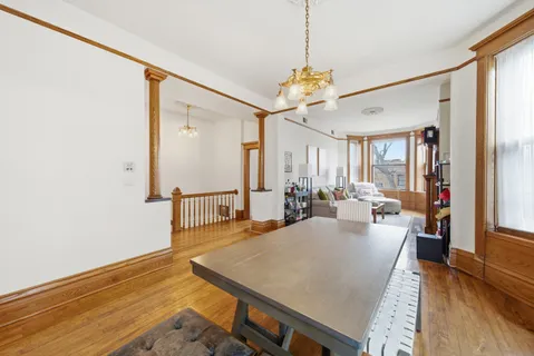 a view of a dining room and livingroom with furniture wooden floor a chandelier
