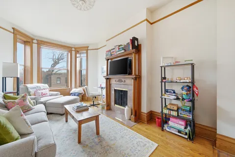a living room with furniture a flat screen tv and a fireplace