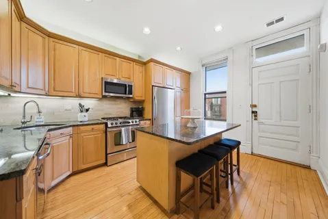 a kitchen with stainless steel appliances granite countertop a stove top oven a sink dishwasher and a refrigerator