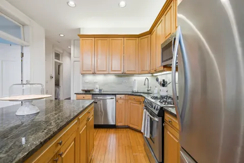 a kitchen with stainless steel appliances granite countertop a sink stove and refrigerator