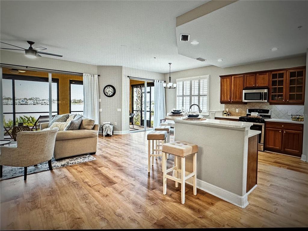 1121 Riverscape Street Bradenton, FL 34208 - Photo 13 of 74 a kitchen with stainless steel appliances granite countertop a stove a sink a refrigerator dining table and chairs