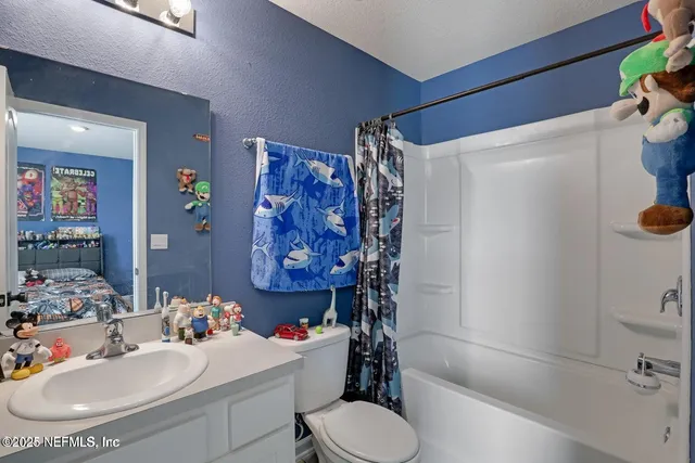 a view of washer and dryer with bathroom in the background