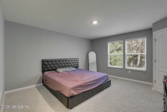 a bedroom with a bed chair and a window