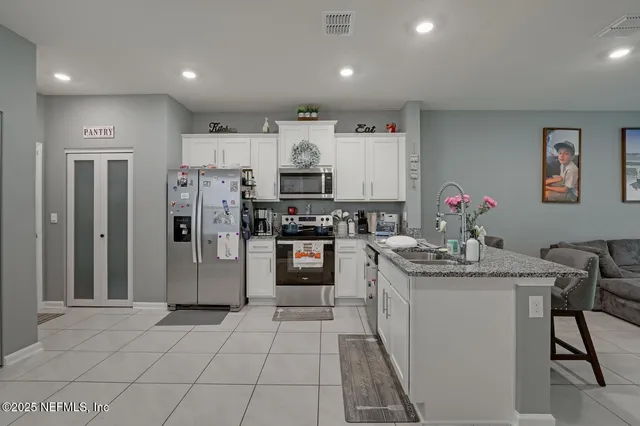 a kitchen with stainless steel appliances kitchen island granite countertop a sink and cabinets