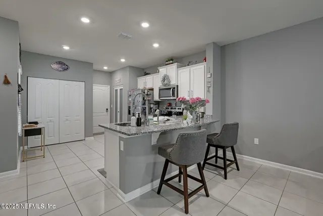 a kitchen with stainless steel appliances granite countertop a refrigerator sink and stove