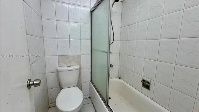 an empty room with wooden floor cabinet and windows