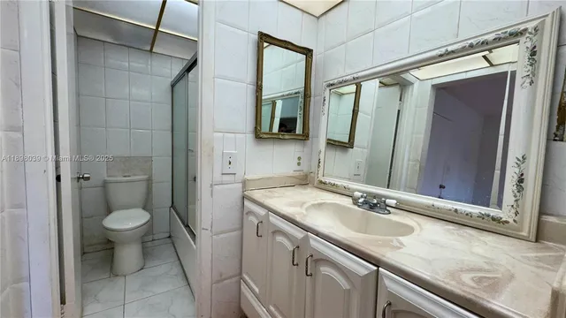 a view of a kitchen with refrigerator and wooden floor