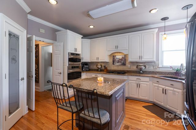 a kitchen with stainless steel appliances granite countertop a stove refrigerator sink and cabinets