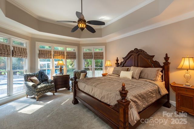 a bedroom with a bed couch and a large window
