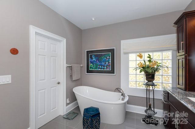 a bathroom with a sink a toilet a window and tub