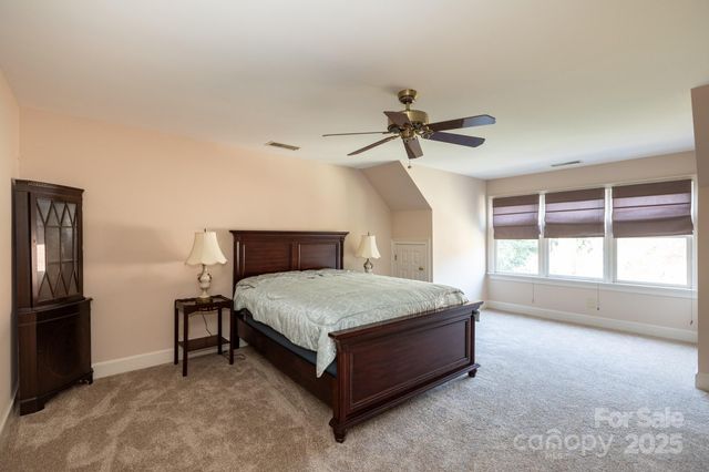 a spacious bedroom with a bed and a ceiling fan