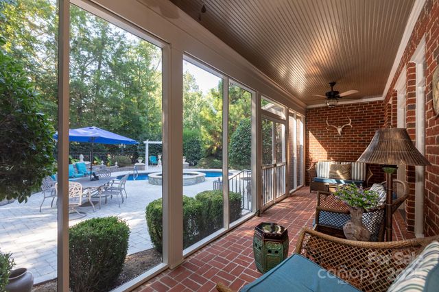 a living room with patio furniture and potted plants