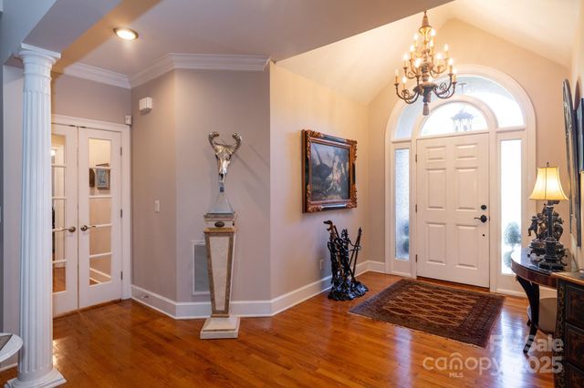a view of a livingroom with wooden floor and a chandelier