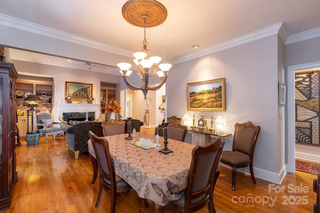 a view of a dining room with furniture a chandelier and wooden floor