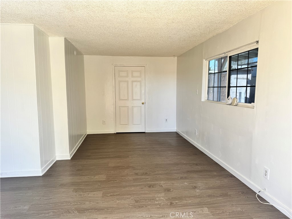 36528 Irwin Road Barstow, CA 92311 - Photo 6 of 35 a view of an empty room with wooden floor and a window