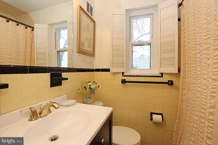 11942 Bluhill Road Silver Spring, MD 20902 - Photo 2 of 30 a bathroom with a sink a toilet and a mirror